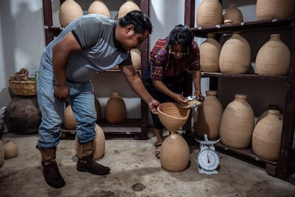 Ixmukane Saloj et son frère Eduardo Saloj remplissent les silos de graines indigènes, dans le village de Chaquijyá, au Guatemala, le 30 août 2024.