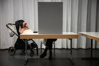 Une femme vote avec son bébé dans une école électorale de Berlin, ce dimanche. 