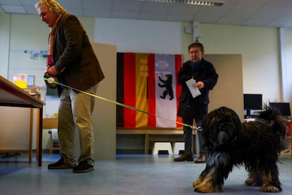 Une personne accompagnée de ses votes pour animaux de compagnie dans un centre de vote de Berlin, ce dimanche. 