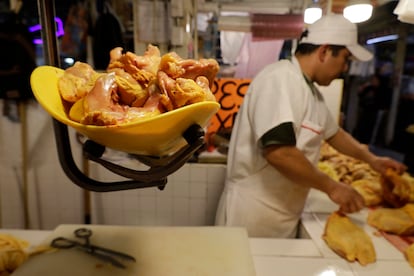 Un homme pèse des morceaux de poulet sur un marché à Mexico, en mars 2024.