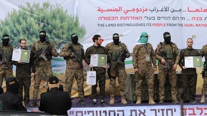 Eliya Cohen (deuxième à gauche) Omer Shem Tov (cinquième) et Omer Wenkert (premier à droite) posent avec des miliciens du Hamas lors de la cérémonie à Nuseirat ce samedi.
