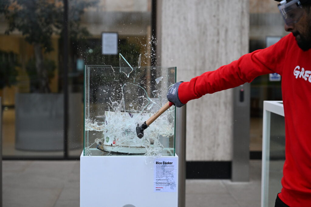 Les militants écrasent des vitrines remplies d'eau présentant des effets répandus au typhon au siège de Shell