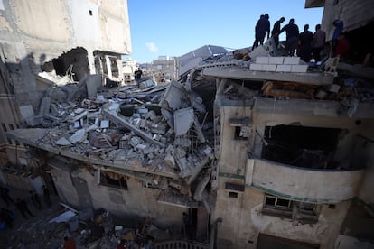 Les gens inspectent une maison après une attaque aérienne israélienne dans la ville de Gaza, ce mercredi.