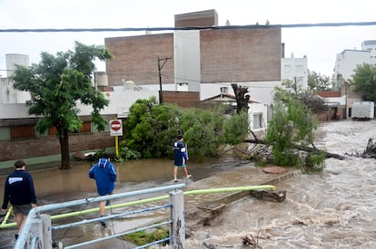 Les gens marchent dans les rues inondées après une tempête, à Bahía Blanca.