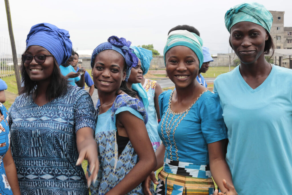 Un groupe de bénévoles vêtus de vêtements bleu vif sourit dans la caméra.