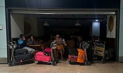 Plusieurs passagers attendent dans une cafétéria à l'aéroport de Barajas, pendant la panne de courant.