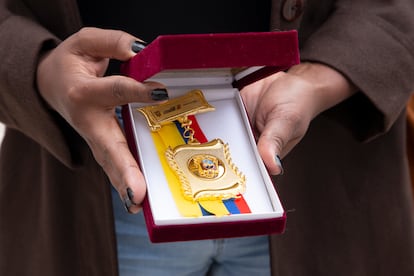 Une femme qui est arrivée à Furukawa à l'âge de 11 ans détient une plaque livrée lors de l'excuse publique.