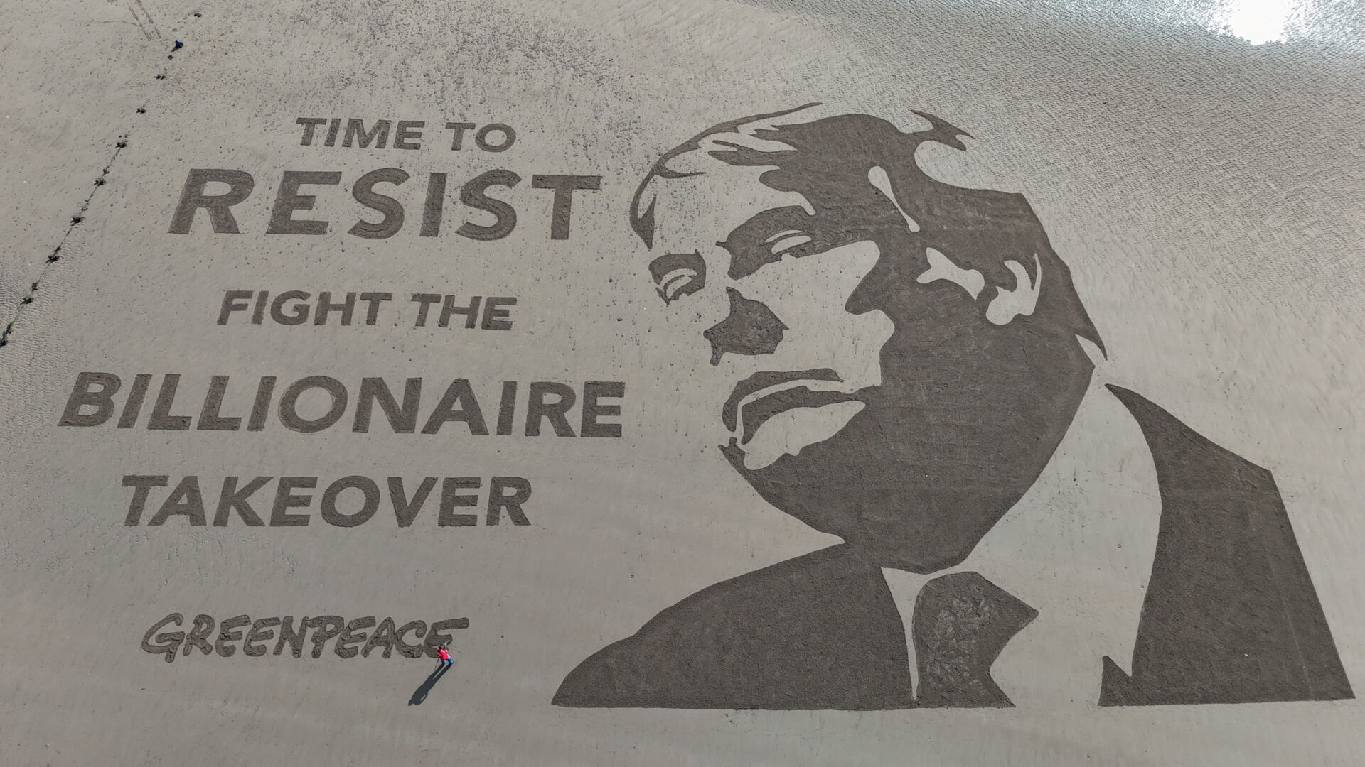 Vue aérienne d'une image de Sandart de Donald Trump et de l'écriture disant: "Il est temps de résister. Combattre la prise de contrôle milliardaire".