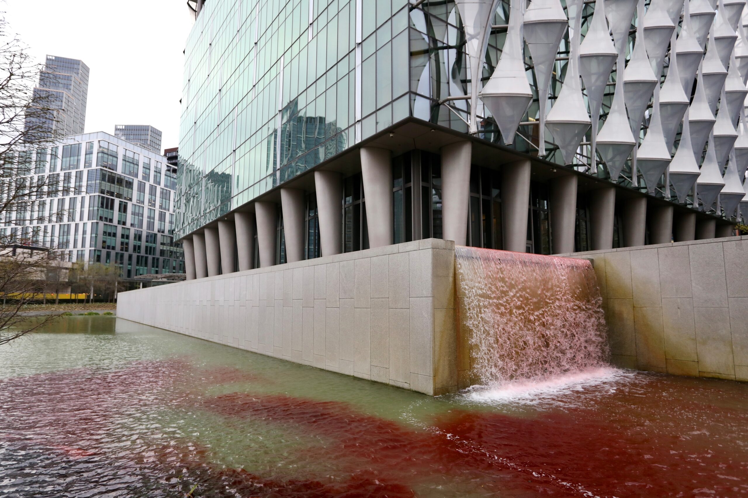 Le colorant rouge du sang tache un étang ornemental et une cascade à l'extérieur de l'ambassade des États-Unis à Londres.