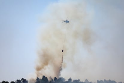 Un hélicoptère jette l'eau dans l'un des foyers du feu de la forêt du sud de la France, ce jeudi.