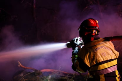 Un pompier éteint l'un des foyers du feu de la forêt à Saint-Laurent-de-la-Cabrerisse, en France.

